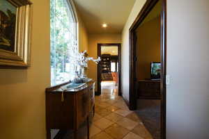 Hall with light tile patterned floors and recessed lighting