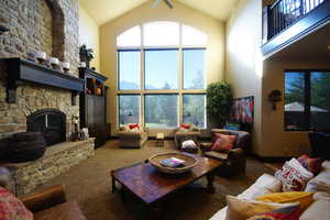 Living area featuring high vaulted ceiling, a fireplace, and carpet floors