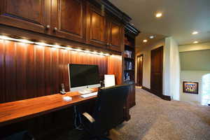 Carpeted home office with recessed lighting and built in study area