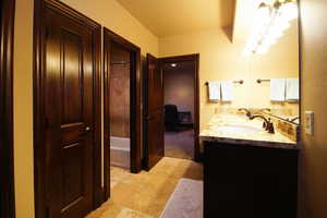 Full bathroom with double vanity, tile patterned flooring, and shower / tub combination