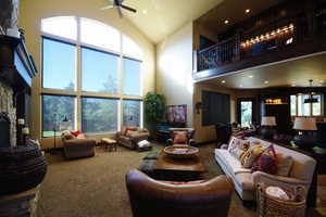 Living room with high vaulted ceiling, ceiling fan, recessed lighting, and carpet floors