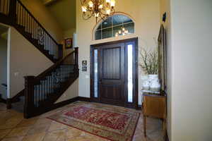 Entryway with a chandelier, a high ceiling, and stairway
