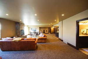 Living area with carpet, recessed lighting, and a fireplace