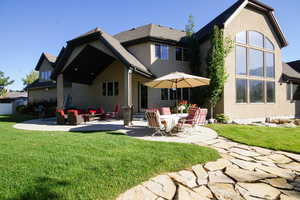 Back of house with a patio area, stucco siding, a lawn, and outdoor lounge area