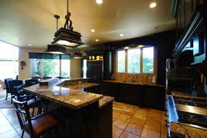 Kitchen with paneled built in fridge, oven, dark stone counters, recessed lighting, and stove