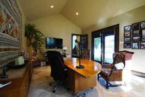 Home office with lofted ceiling and recessed lighting