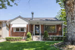 View of front of house with brick siding and a front lawn