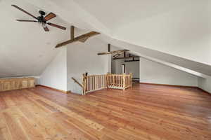 Bonus room with light wood-style flooring and ceiling fan