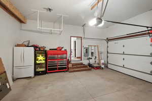 Garage with freestanding refrigerator and electric panel