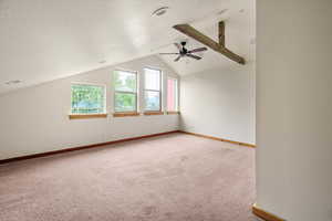 Bonus room with light carpet, a ceiling fan, and vaulted ceiling