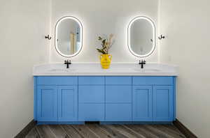 Bathroom with double vanity and wood finished floors