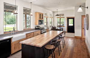Kitchen featuring black appliances, wooden counters, light brown cabinets, light wood finished floors, and recessed lighting