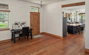 Office space with wood-type flooring and a chandelier