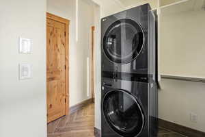 Laundry room featuring estacked washer and dryer and baseboards