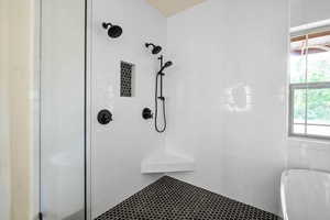 Bathroom featuring tiled shower and a soaking tub