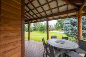 Deck with a lawn and outdoor dining space