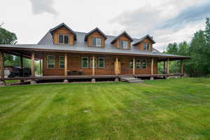 View of front of property with a front yard, covered porch, and a metal roof
