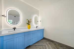 Full bathroom with double vanity and baseboards