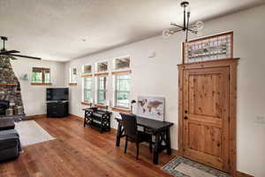 Entryway with wood-type flooring, a ceiling fan, a chandelier, and a textured ceiling