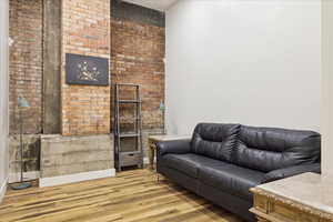 Living area featuring light wood-style flooring and brick wall