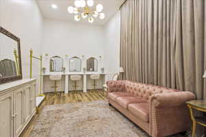 Bathroom featuring wood finished floors, a chandelier, and vanity