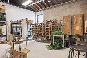 Wine area featuring brick wall and concrete floors