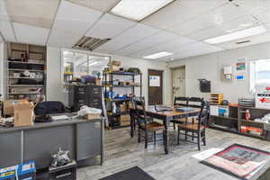 Dining room featuring a paneled ceiling, wood finished floors, and an office area