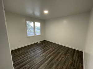 Spare room with dark wood-type flooring and recessed lighting