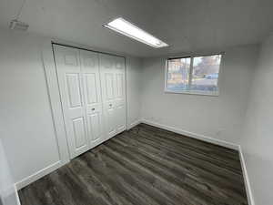 Unfurnished bedroom with dark wood-type flooring and a closet