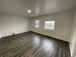 Unfurnished room with dark wood-style floors and recessed lighting