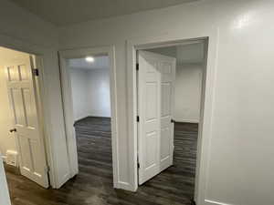 Hallway featuring dark wood-type flooring and baseboards