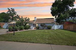 View of front of property with driveway, a chimney, and brick siding