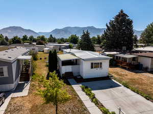 View of front of home featuring a residential view, stairway, a metal roof, a deck with mountain view, and a front lawn