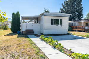 Manufactured / mobile home featuring a deck and a front yard