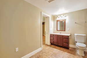 Bathroom featuring vanity, tile patterned floors, and a textured ceiling