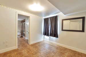 Tiled empty room with baseboards and a textured ceiling