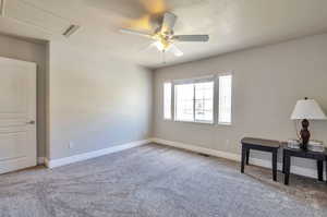 Empty room with carpet floors, a ceiling fan, and a textured ceiling