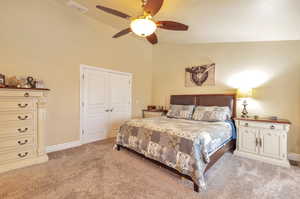 Bedroom featuring light carpet, high vaulted ceiling, a closet, and ceiling fan