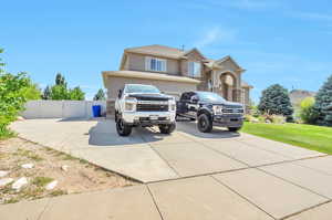 Traditional-style house featuring driveway, stucco siding, and stone siding