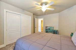 Bedroom with carpet, a closet, and a ceiling fan