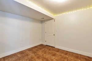 Empty room with baseboards and a textured ceiling