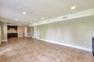 Unfurnished living room with recessed lighting and baseboards