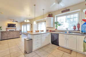 Kitchen with dishwasher, a ceiling fan, open floor plan, and light tile patterned floors