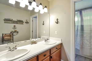 Full bath with double vanity and tile patterned flooring