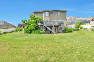 Back of house featuring stairway, a fenced backyard, stucco siding, and a deck with mountain view