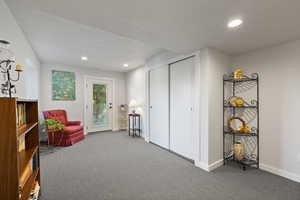 Living area featuring carpet flooring, recessed lighting, and a textured ceiling