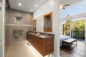 Bathroom featuring recessed lighting, double vanity, a ceiling fan, a shower stall, and wood finished floors