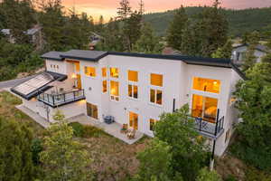 Rear view of property featuring a balcony, a patio area, and stucco siding