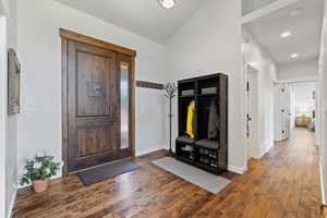 Foyer entrance featuring dark wood-type flooring, vaulted ceiling, and recessed lighting