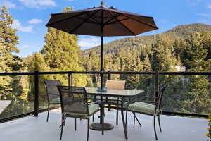 Balcony featuring a forest view and a mountain view